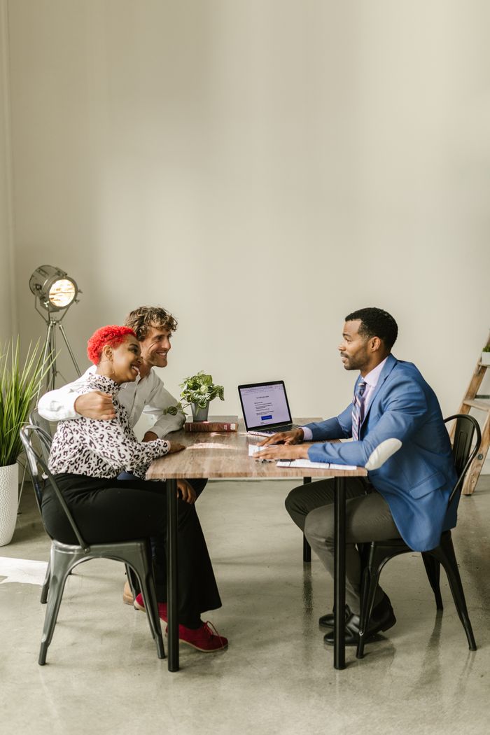 The Art of Drawing Readers In: Your attractive post title goes here A professional financial advisor discusses options with a couple in a modern office setting.